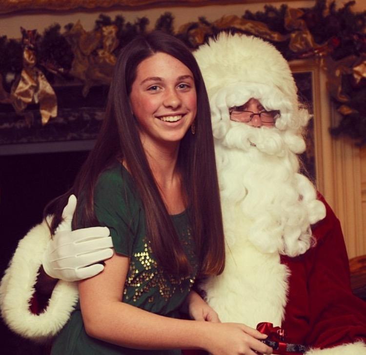 Junior+Maddie+McLane+sits+on+Santas+lap%2C+carrying+out+a+family+tradition.+