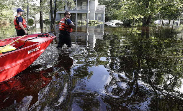 Members of the United States Coast Guard Shallow Water Rescue Team waddle through a flooded neighborhood in Lumberton, North Carolina, September 17.  Courtesy of cbsnews.com.  Gerry Broome, AP 
